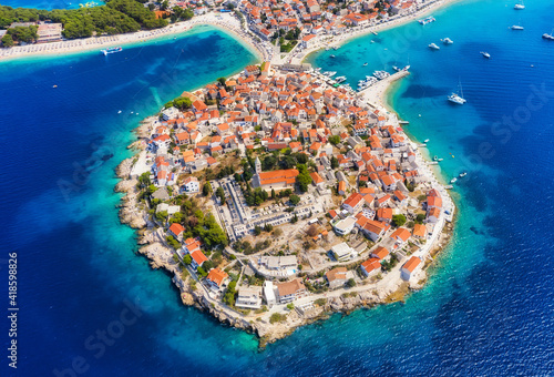 Primosten town, Croatia. View of the city from the air. Seascape with beach and old town. View from drone on the peninsula with houses. Landscape during sunset. Travel and vacation image
