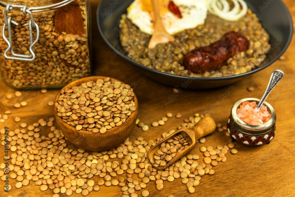 Lentils with sausage and chili. Grilled sausage and lentils with egg on a black plate. Legumes. Healthy food. Lentils with sausage and chili. Grilled sausage and lentils with egg on a black plate. Legumes. Healthy food.