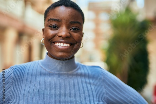 Young african american woman smiling happy standing at the city.