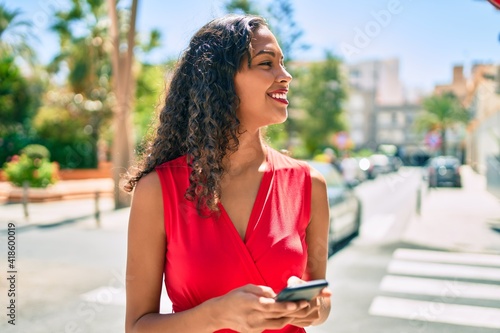 Young african american girl smiling happy using smartphone at city.