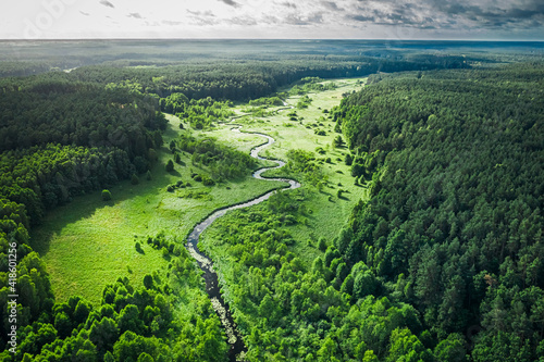 Curvy river and green forest at sunrise, aerial view