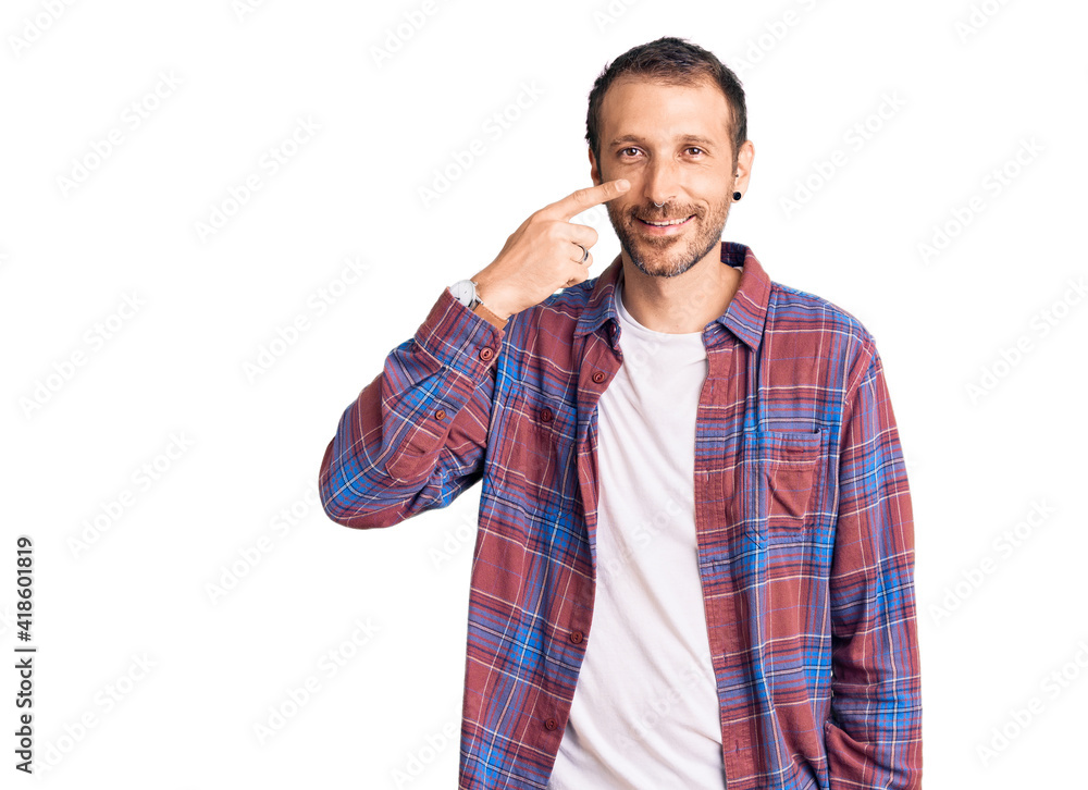 Young handsome man wearing casual clothes pointing with hand finger to face and nose, smiling cheerful. beauty concept Young handsome man wearing casual clothes pointing with hand finger to face and nose, smiling cheerful. beauty concept