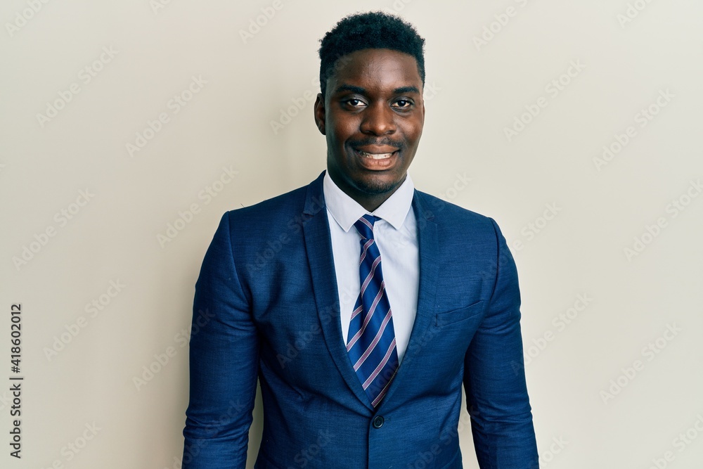 Handsome black man wearing business suit and tie with a happy and cool smile on face. lucky person. Handsome black man wearing business suit and tie with a happy and cool smile on face. lucky person.