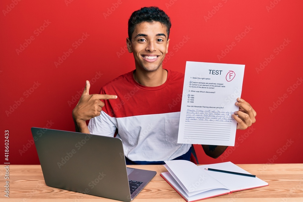 Young handsome african american man showing failed exam pointing finger to one self smiling happy and proud Young handsome african american man showing failed exam pointing finger to one self smiling happy and proud