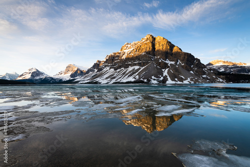 Partially frozen Bow Lake in Banff National Park surrounded by the Canadian Rockies at sunrise 