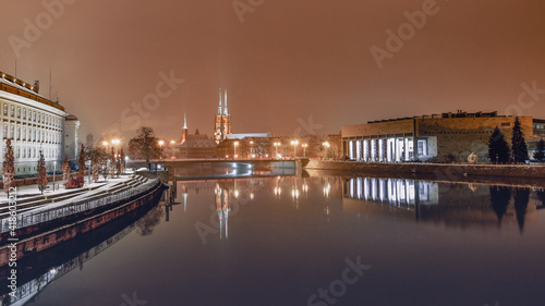 The University Library in Wroclaw on the banks of the Odra River, illuminated at night.