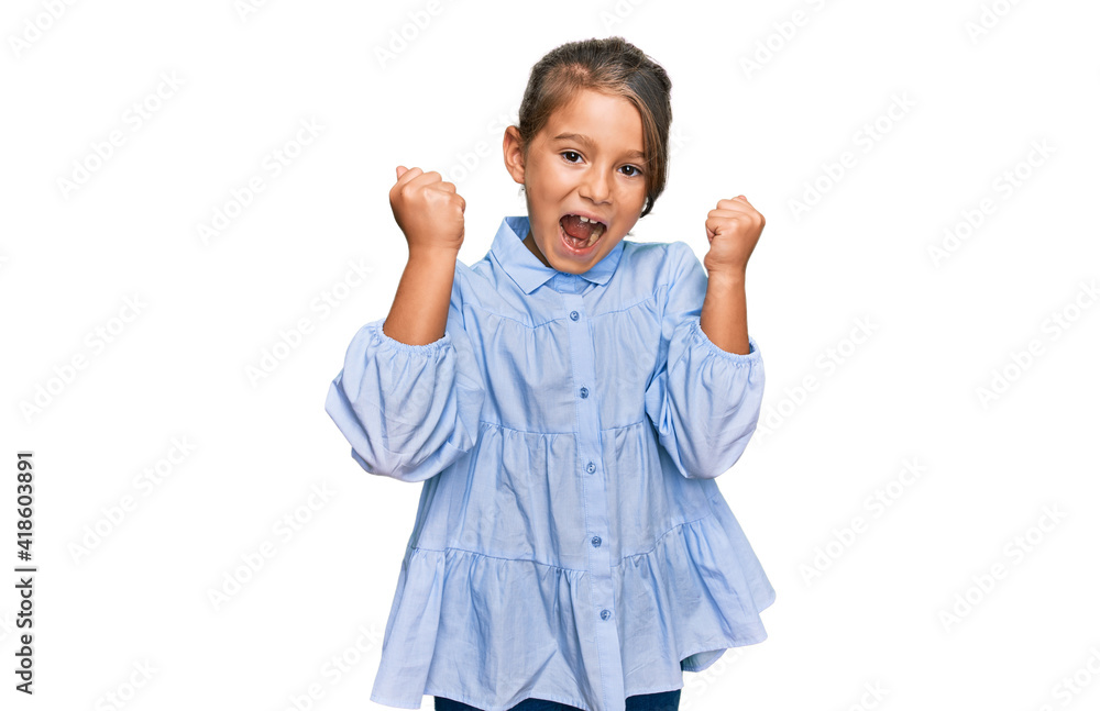 Little beautiful girl wearing casual clothes screaming proud, celebrating victory and success very excited with raised arms Little beautiful girl wearing casual clothes screaming proud, celebrating victory and success very excited with raised arms