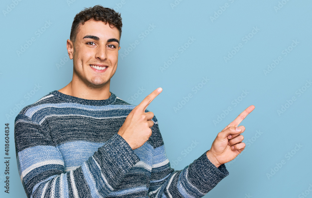 Hispanic young man wearing casual clothes smiling and looking at the camera pointing with two hands and fingers to the side. Hispanic young man wearing casual clothes smiling and looking at the camera pointing with two hands and fingers to the side.