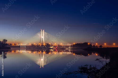 Wroclaw Redzinski Bridge over the Odra River, the illuminated bridge is reflected in the water.