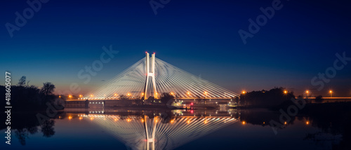 Wroclaw Redzinski Bridge over the Odra River, the illuminated bridge is reflected in the water.