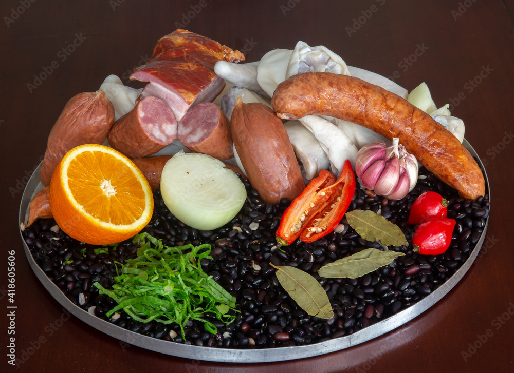 Typically Brazilian feijoada, ingredients, pepperoni sausage, paio, pepper, pork, black beans, bay leaf, cracklings and caipirinha with lemon and cachaça