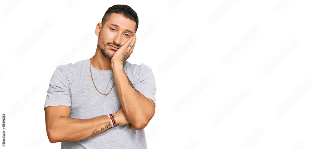 Handsome man with tattoos wearing 90s style thinking looking tired and bored with depression problems with crossed arms. Handsome man with tattoos wearing 90s style thinking looking tired and bored with depression problems with crossed arms.
