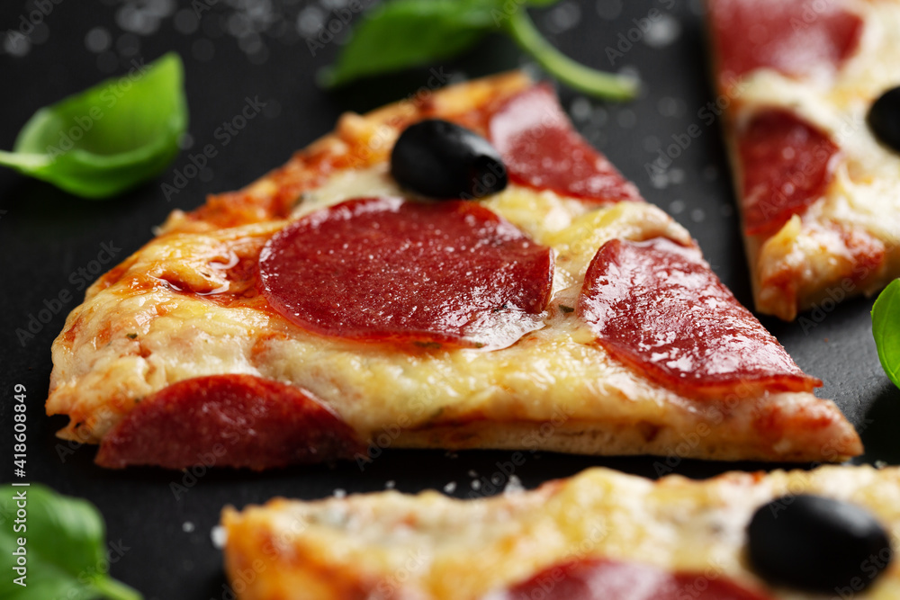 Pizza with salami and cheese on dark Pizza with salami and cheese on dark