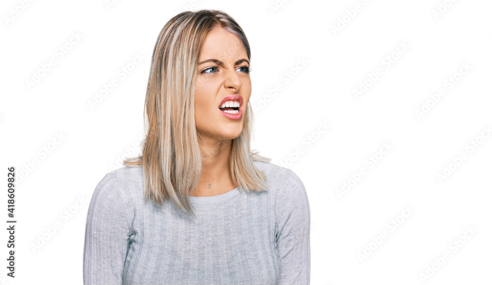 Beautiful blonde woman wearing casual clothes angry and mad screaming frustrated and furious, shouting with anger. rage and aggressive concept. Beautiful blonde woman wearing casual clothes angry and mad screaming frustrated and furious, shouting with anger. rage and aggressive concept.