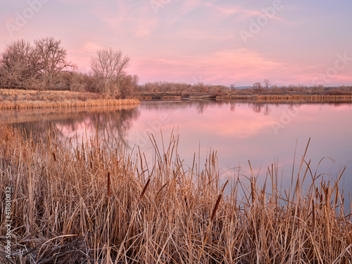 early spring dawn over a calm lake in one of natural areas along the Poudre River in Fort Collins  Colorado