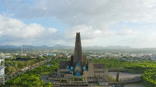 Modern temple against the backdrop of the urban landscape of a tropical country. Aerial view of Basilica Cathedral in Higuey Dominican Republic. Religion of Central America. photo