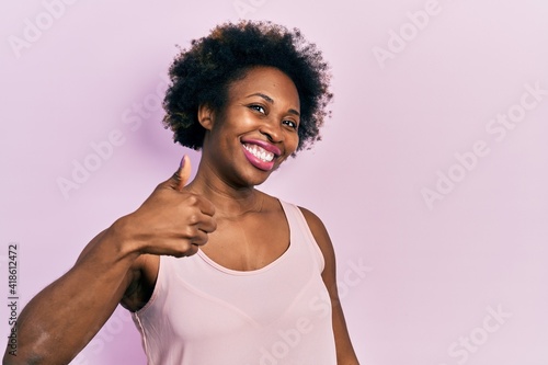 Young african american woman wearing casual sleeveless t shirt doing happy thumbs up gesture with hand. approving expression looking at the camera showing success.