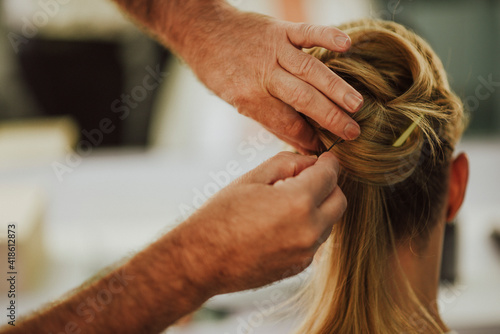 Caucasian hairdresser man doing a wedding bow to a young blond Caucasian woman