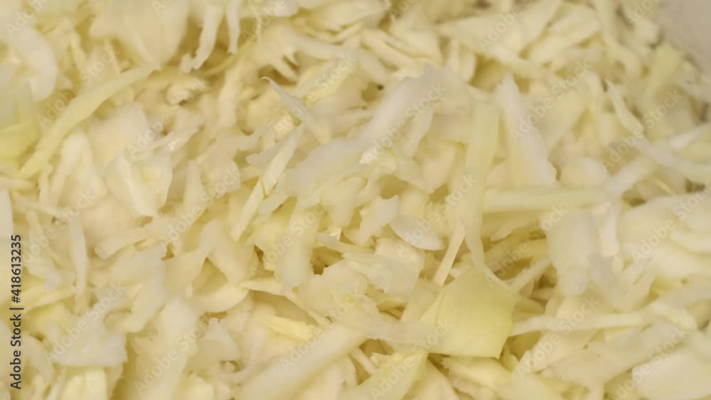 finely chopped white cabbage close-up rotates on the turntable around its axis. finely chopped white cabbage close-up rotates on the turntable around its axis.