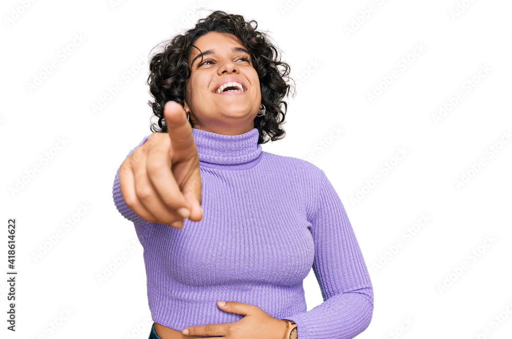Young hispanic woman with curly hair wearing casual clothes laughing at you, pointing finger to the camera with hand over body, shame expression Young hispanic woman with curly hair wearing casual clothes laughing at you, pointing finger to the camera with hand over body, shame expression