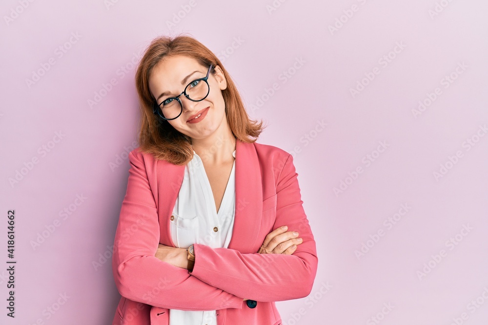 Young caucasian woman wearing business style and glasses happy face smiling with crossed arms looking at the camera. positive person. Young caucasian woman wearing business style and glasses happy face smiling with crossed arms looking at the camera. positive person.