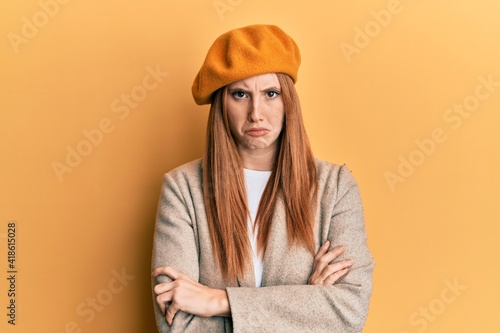 Young irish woman wearing french look with beret skeptic and nervous, disapproving expression on face with crossed arms. negative person.