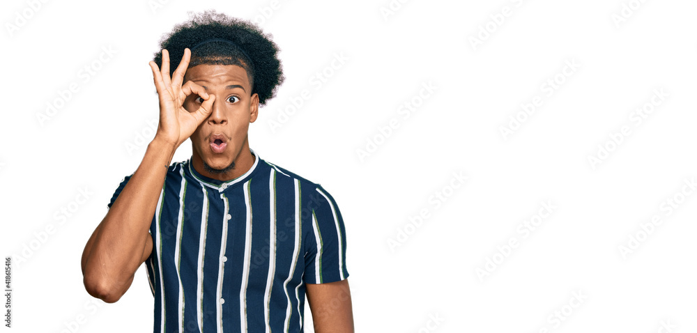 African american man with afro hair wearing casual clothes doing ok gesture shocked with surprised face, eye looking through fingers. unbelieving expression. African american man with afro hair wearing casual clothes doing ok gesture shocked with surprised face, eye looking through fingers. unbelieving expression.