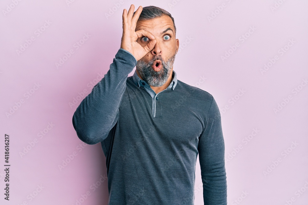 Middle age handsome man wearing casual clothes doing ok gesture shocked with surprised face, eye looking through fingers. unbelieving expression. Middle age handsome man wearing casual clothes doing ok gesture shocked with surprised face, eye looking through fingers. unbelieving expression.
