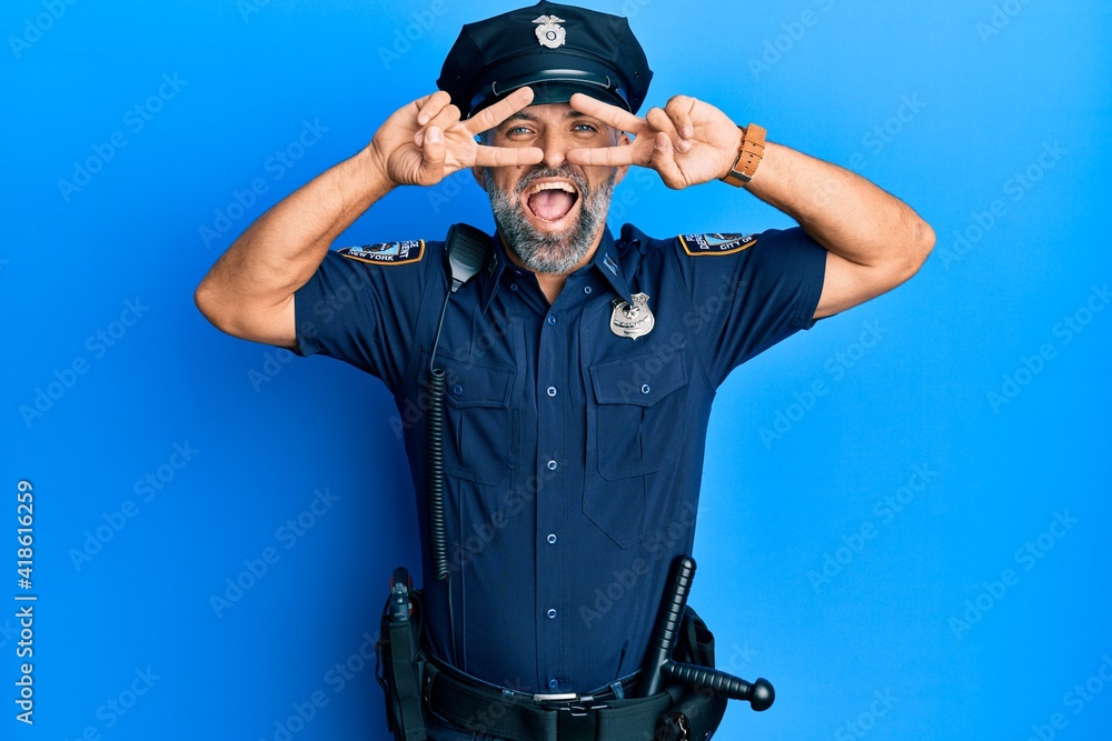 Middle age handsome man wearing police uniform doing peace symbol with fingers over face, smiling cheerful showing victory Middle age handsome man wearing police uniform doing peace symbol with fingers over face, smiling cheerful showing victory