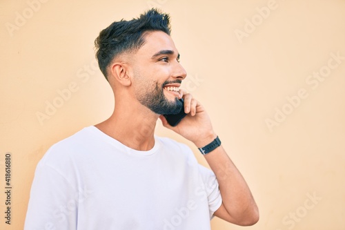 Young arab man with serious expression talking on the smartphone at the city.