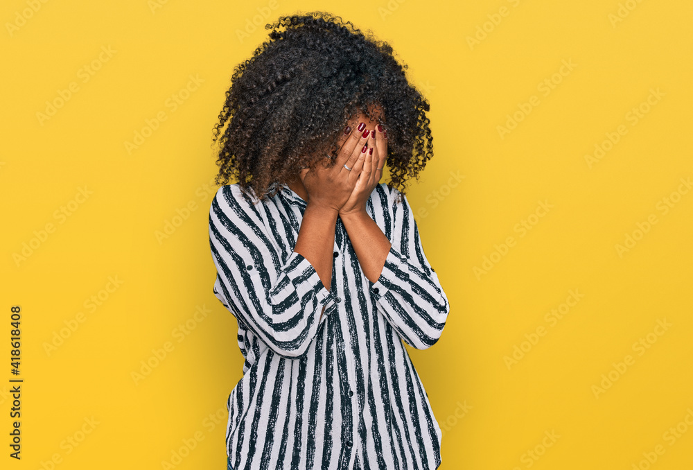 Young african american girl wearing casual clothes with sad expression covering face with hands while crying. depression concept. Young african american girl wearing casual clothes with sad expression covering face with hands while crying. depression concept.