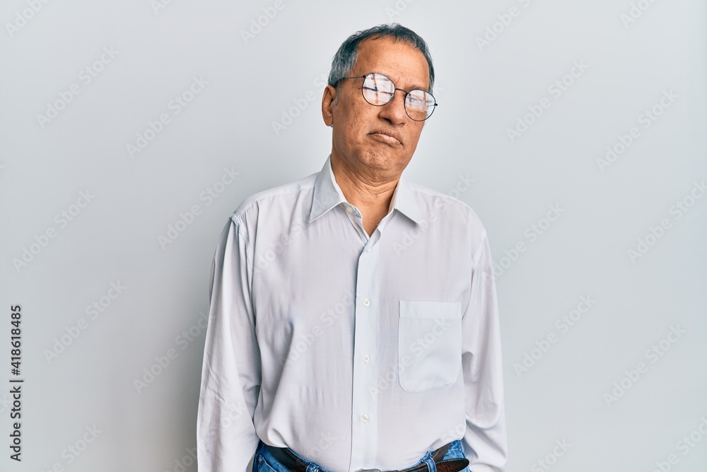 Middle age indian man wearing casual clothes and glasses depressed and worry for distress, crying angry and afraid. sad expression. Middle age indian man wearing casual clothes and glasses depressed and worry for distress, crying angry and afraid. sad expression.