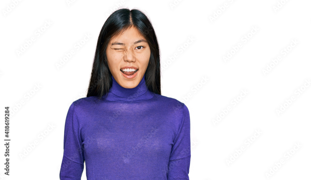 Beautiful young asian woman wearing casual clothes winking looking at the camera with sexy expression, cheerful and happy face. Beautiful young asian woman wearing casual clothes winking looking at the camera with sexy expression, cheerful and happy face.