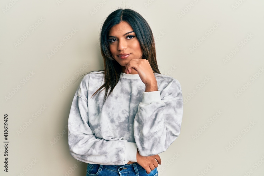 Young latin transsexual transgender woman wearing casual clothes thinking concentrated about doubt with finger on chin and looking up wondering Young latin transsexual transgender woman wearing casual clothes thinking concentrated about doubt with finger on chin and looking up wondering