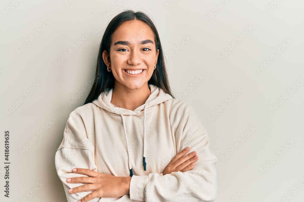 Young asian woman wearing casual sweatshirt happy face smiling with crossed arms looking at the camera. positive person. Young asian woman wearing casual sweatshirt happy face smiling with crossed arms looking at the camera. positive person.