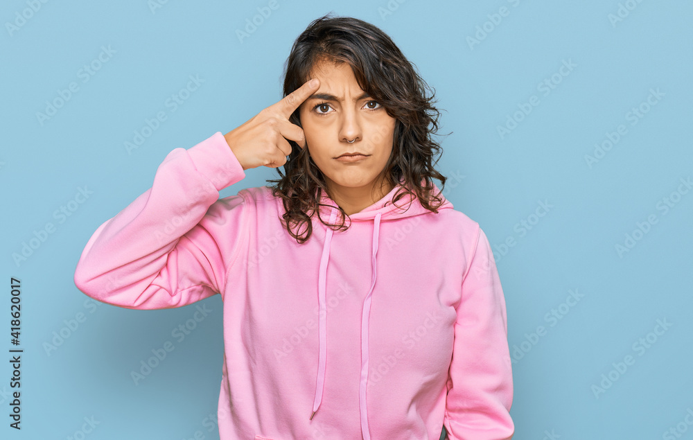 Young hispanic woman wearing casual sweatshirt pointing unhappy to pimple on forehead, ugly infection of blackhead. acne and skin problem Young hispanic woman wearing casual sweatshirt pointing unhappy to pimple on forehead, ugly infection of blackhead. acne and skin problem