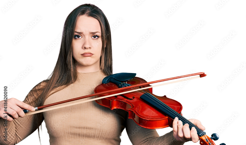 Young hispanic girl playing violin depressed and worry for distress, crying angry and afraid. sad expression. Young hispanic girl playing violin depressed and worry for distress, crying angry and afraid. sad expression.
