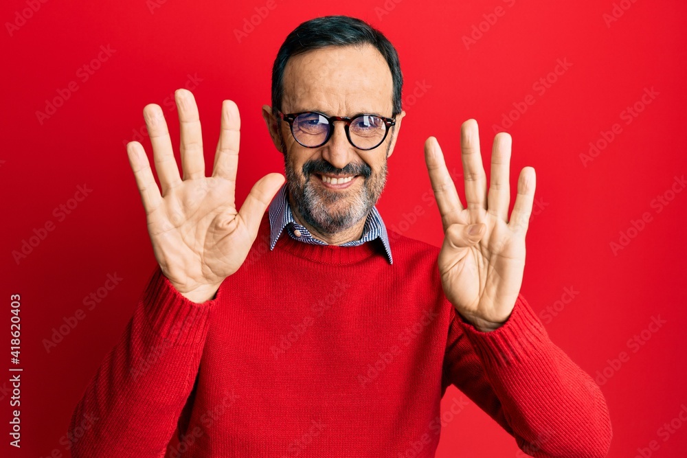 Naklejka premium Middle age hispanic man wearing casual clothes and glasses showing and pointing up with fingers number nine while smiling confident and happy.