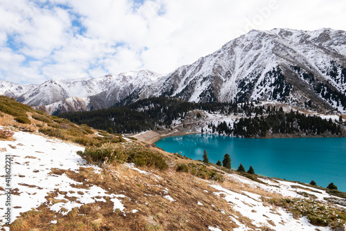 Big Almaty Lake in Kazakhstan in a cold winter day. Snow visible around the Alpine Lake, Almaty city main source of drinking water.