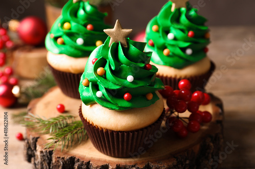 Christmas tree shaped cupcakes on wooden stand, closeup