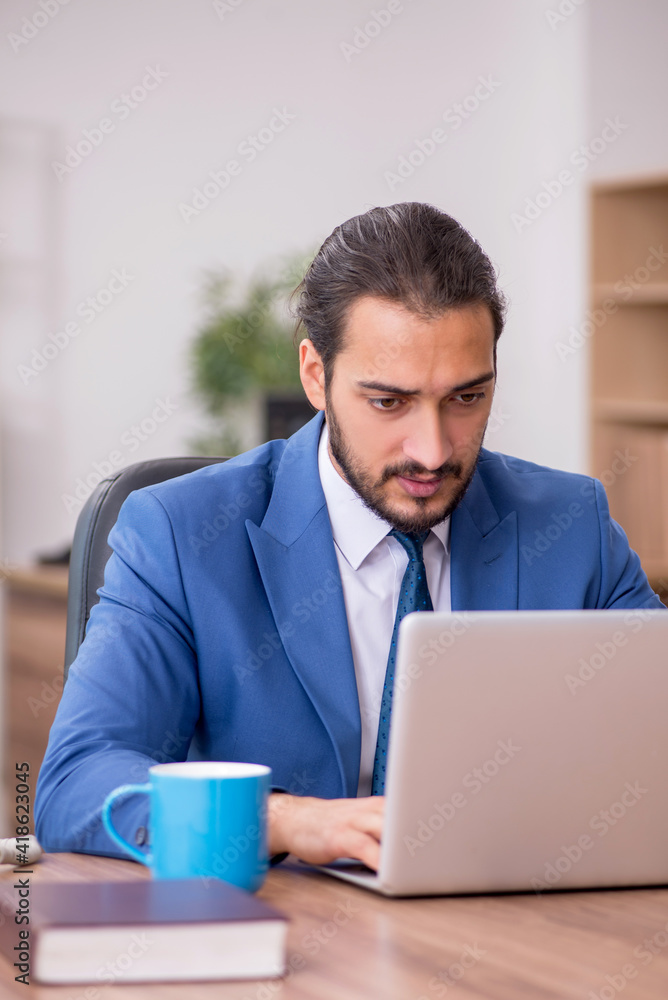 Young male employee working in the office Young male employee working in the office