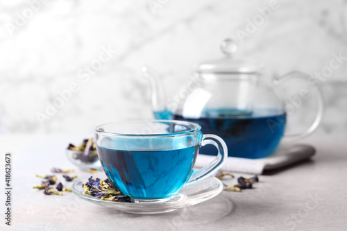 Glass cup of organic blue Anchan on light table, space for text. Herbal tea