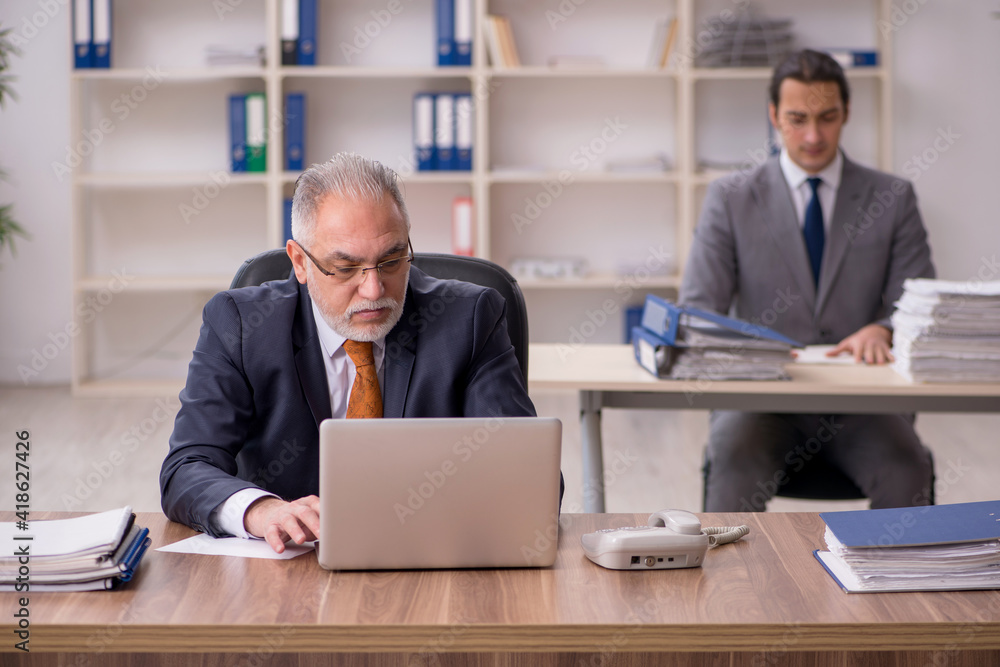 Two employees sitting at workplace Two employees sitting at workplace