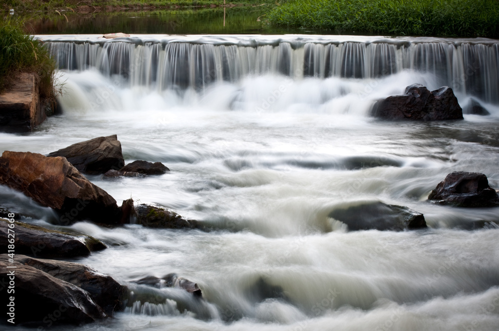 Fototapeta premium Small waterfall full of rocks in a river in the brazilian countryside.