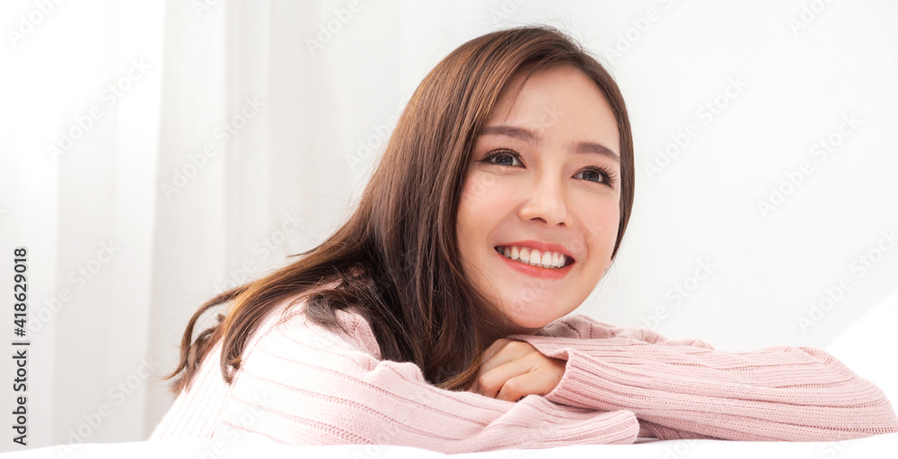 Smiling of cheerful beautiful pretty asian woman clean fresh healthy white skin posing in warm knitted pink clothes.Girl felling relaxing and enjoy time on the bed at home.asia beauty Smiling of cheerful beautiful pretty asian woman clean fresh healthy white skin posing in warm knitted pink clothes.Girl felling relaxing and enjoy time on the bed at home.asia beauty