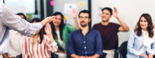 Businesswoman coach speaker presentation and discussing meeting strategy sharing idea.Creative casual business people showing hand to answer question in conference seminar at hall.presentation 