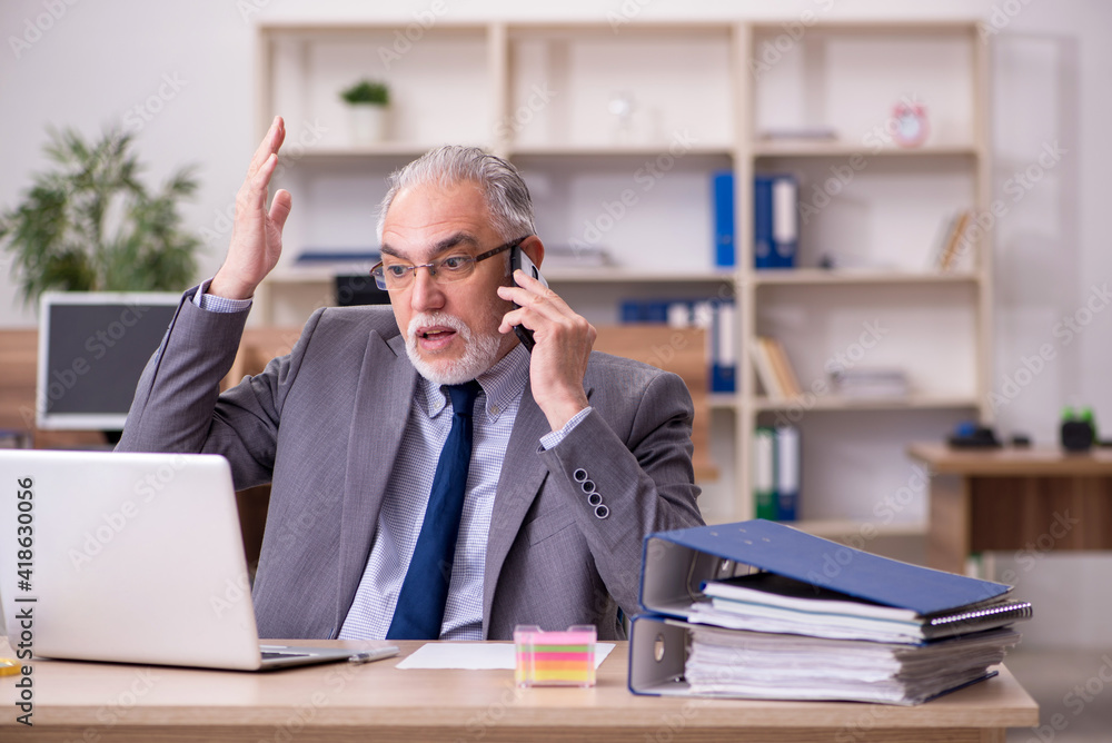 Old male employee working in the office Old male employee working in the office