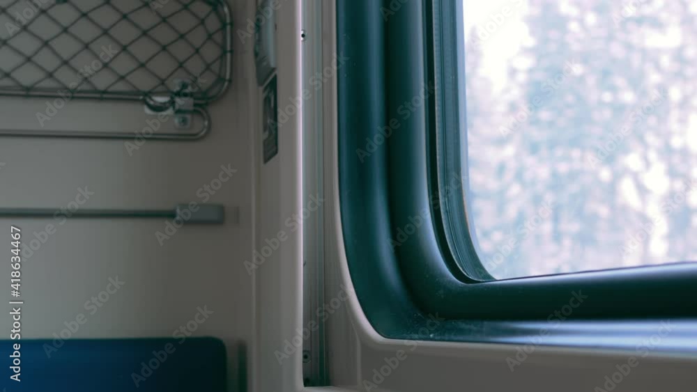 The second-class cabin of a passenger train without passengers. From the lower seat for the passengers of the train, the forest is visible through the window. There is a mesh pocket on the wall. The second-class cabin of a passenger train without passengers. From the lower seat for the passengers of the train, the forest is visible through the window. There is a mesh pocket on the wall.