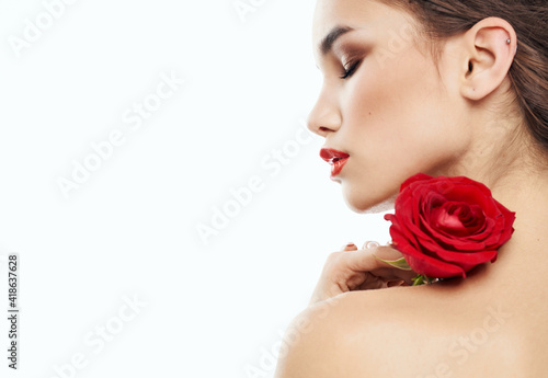 sexy woman with red flower on shoulder on light background cropped back view