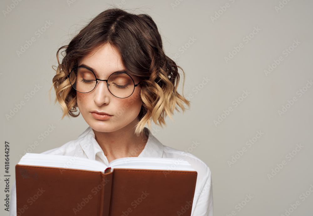 Woman with notepad in hands business finance glasses on her face Woman with notepad in hands business finance glasses on her face